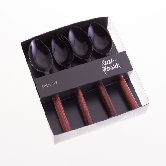 A set of 4 egg spoons in a clear box with black card insert