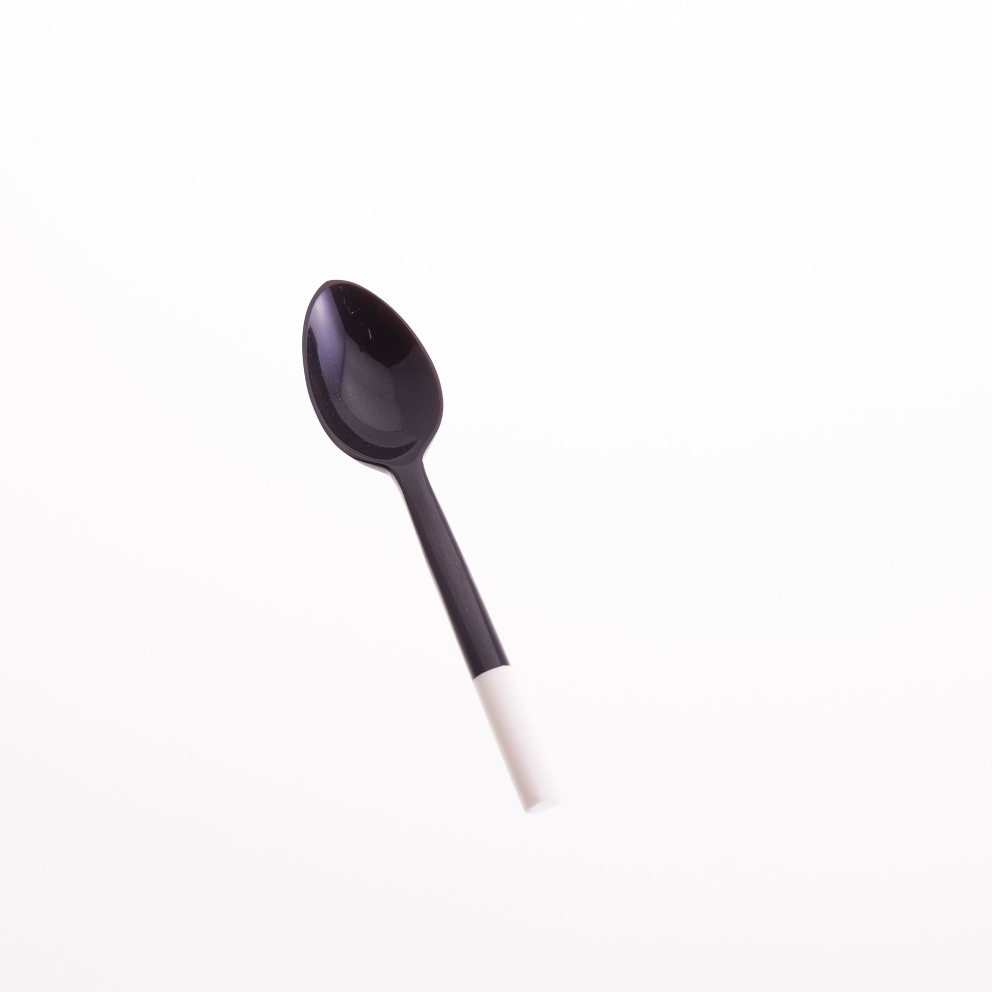 A black horn egg spoons with a white bone tip