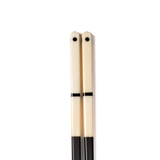 A pair of horn and bone chop sticks with black dot detail
