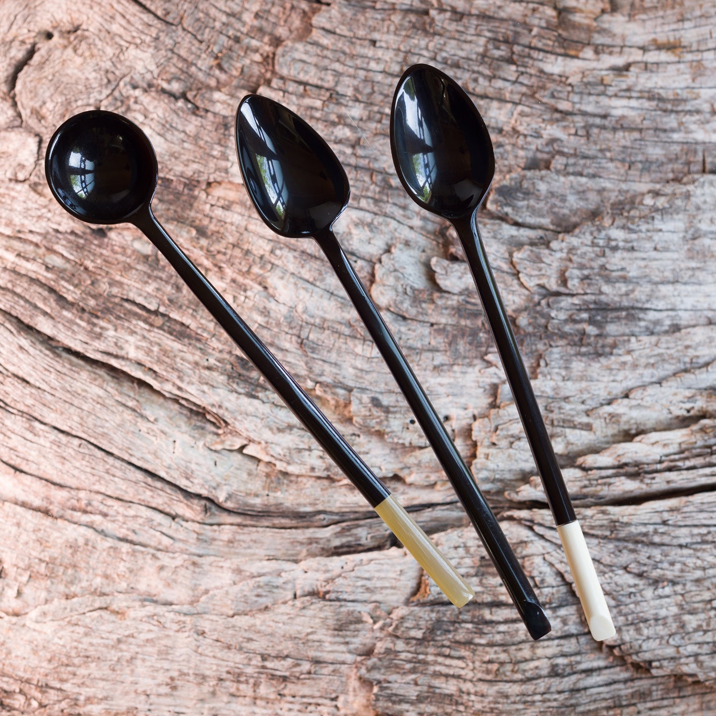 A set of 3 long handled jam spoons. The first is black horn with a natural horn tip, the second is black horn and the third is black horn with a bone tip